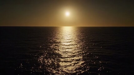 Obraz premium Sunlight reflecting off the surface of a calm sea, with a soft glow illuminating the horizon.