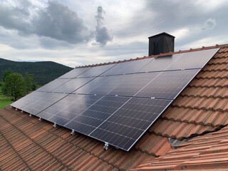 Red Tiled Roof of a Residential House with Installed Solar Panels