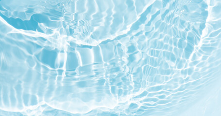 Blue water with ripples on the surface. Defocus blurred transparent blue colored clear calm water surface texture with splashes and bubbles. Water waves with shining pattern texture background.