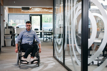In a large modern corporation, a determined businessman in a wheelchair navigates through a...
