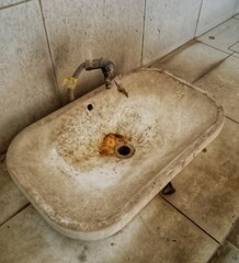 Old and rusty sink showing signs of neglect and poor maintenance in a restroom.