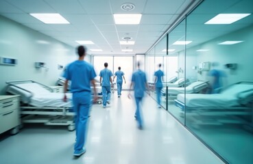 Hospital corridor with unrecognizable medical personnel walking. Modern facility with clean, sterile design. Long exposure effect creates motion blur showing movement. Hospital staff move