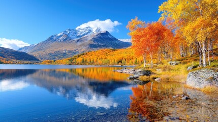 Obraz premium Autumnal lake reflecting snowy mountains; colorful trees
