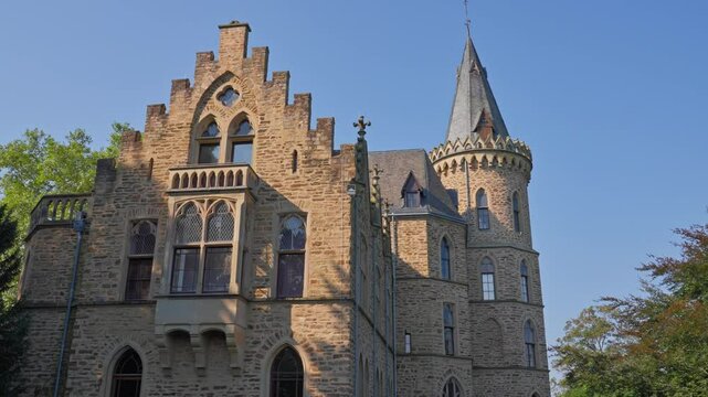 Exterior detail of an elegant medieval castle and tower on a cloudless day with parallax tracking movement, Germany