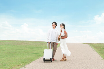 夏の旅行・ハネムーン・新婚旅行に出かける男女のカップル・夫婦
