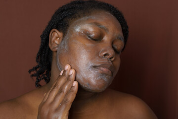 Applying a face wash on brown skin, cleansing Brown skin with dark spots, washing hyperpigmented...