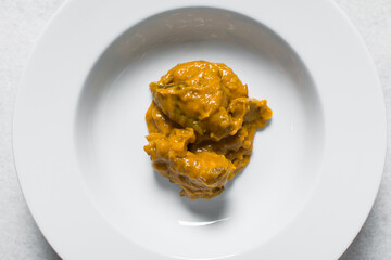 Overhead view of Nigerian owo soup with fish and beef in a white plate, top view of oghwo soup in a large dinner plate