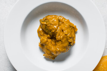 Overhead view of Nigerian owo soup with fish and beef in a white plate, top view of oghwo soup in a large dinner plate