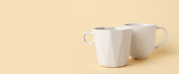 White ceramic empty mugs on beige background