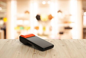 Payment terminal on wooden counter in store