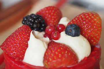 Fresh fruit dessert topped with cream and berries