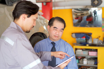 Obraz premium Technician talks with customer in garage.