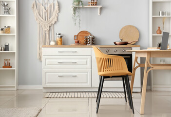 Interior of light kitchen with white counters and dining table