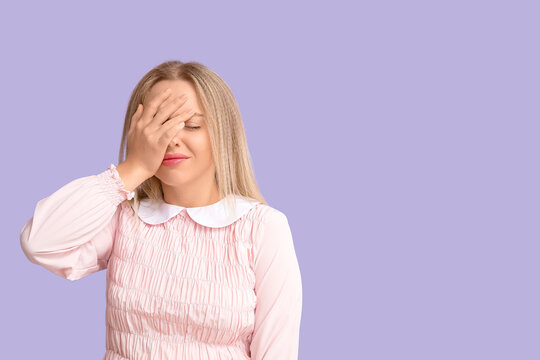 Young woman doing facepalm on lilac background