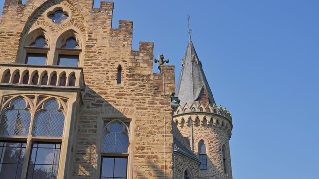 Closeup exterior detail of an elegant medieval castle and tower on a cloudless day with parallax tracking movement, Germany