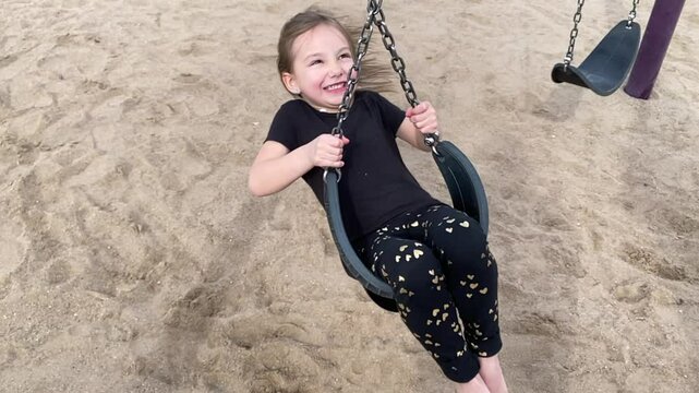 Child Spinning on a Swingset