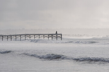 winter king tide ocean waves hitting the pier