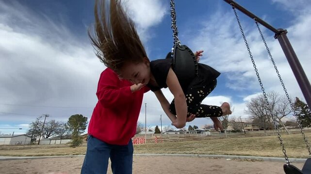 Grandpa Spinning Granddaughter on the Swingset in Slow Motion