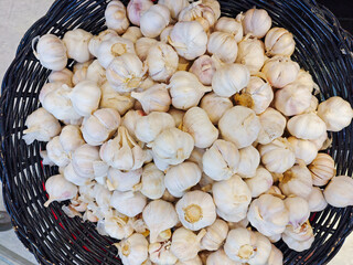 Fresh Garlic Bulbs in a Woven Basket on a Bright Background