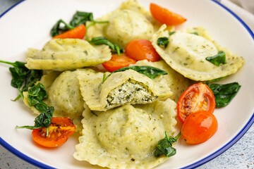 Bowl of tasty ravioli with vegetables on table