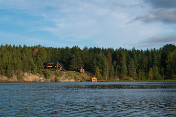 Wooden log house and chapel on the shore of Lake Ladoga near the village of Lumivaara on a sunny autumn day, Ladoga skerries, Lahdenpohya, Republic of Karelia, Russia