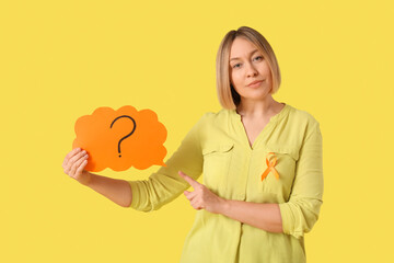Mature woman with ribbon pointing at speech bubble on yellow background. Multiple Sclerosis...