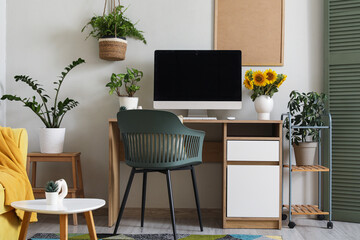 Interior of living room with workplace and plants