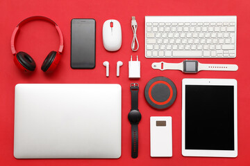 Set of modern devices on red background, top view