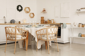 Festive table setting with fir branches in kitchen
