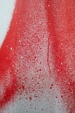 Close up of spray painted surface in red and white