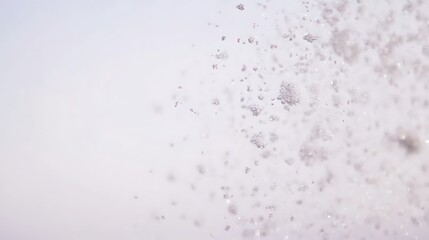 Water droplets falling against a light background