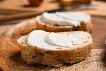 Tasty bruschetta with processed cheese on wooden plate, closeup