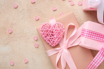 Gift boxes with pink heart shaped decor on beige grunge background. Valentine's Day celebration