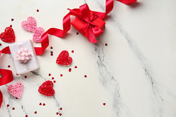 Gift boxes with ribbon and heart shaped decor on white grunge background. Valentine's Day celebration