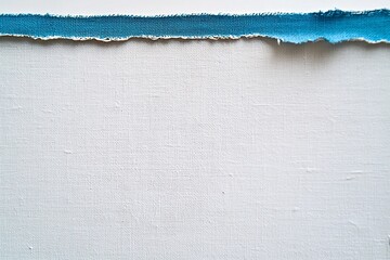 A close-up view of a torn edge of blue fabric against a textured white background, showcasing textile detail