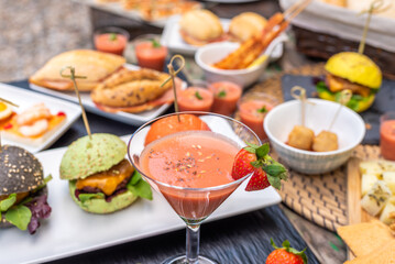 Diverse selection of food and a cocktail for a event or celebration.