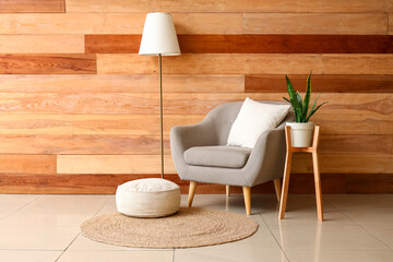 Interior of stylish living room with grey armchair, standard lamp and houseplant