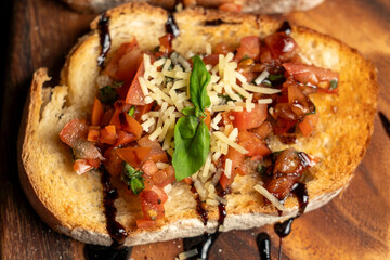 Bruschetta with Tomato Topping, Basil, and Balsamic Glaze on Wooden Serving Board in Rustic Setting  