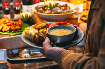 People are taking Asian cuisine from hand to hand in a buffet style in the hotel room