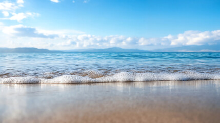 Obraz premium Gentle waves on sandy beach with blue sky. Coastal landscape and vacation destination concept