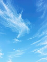 A tranquil serene blue sky with just a few thin wispy clouds floating gently across it, tranquility, cloudless sky