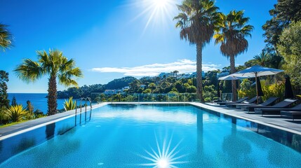 Obraz premium Luxury Swimming Pool in Opulent Hotel Resort Surrounded by Swaying Palm Trees and Set Against a Clear Blue Sky. Offers a Breathtaking Panoramic View of Sparkling Water, Creating an Idyllic Escape.