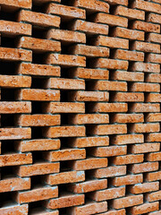 Background or backdrop of brown brick wall texture. Lattice brown brick wall background. Beautiful and artistic brown burnt brick wall with gapped brickwork. House fence with neatly arranged bricks.