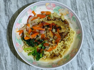 Mie, Mie ayam, mi ayam, or bakmi ayam is a common Indonesian dish consisting of seasoned yellow wheat noodles topped with chicken pieces. This dish originates from Chinese culinary techniques.