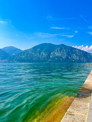 View of Iseo Lake Surrounded by Majestic Mountains and Clear Blue Skies, Italy