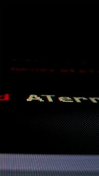 Closeup macro shot movement of coding script moving across LED screen with real-time AI-generated typing, showcasing advanced AI learning in optimization, debug and coding for software development.