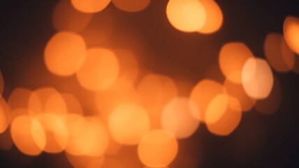 Fototapeta premium Golden bokeh lights with a warm glow, defocused circles creating a festive ambiance in soft orange and yellow tones.