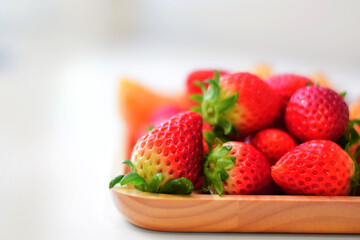 Strawberries on wooden tray and white background