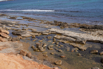 small archaeological ruins, from a Roman quarry, at the water limit of a beach, Pilar de la Horadada, can be seen very well as the water is practically calm