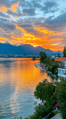 Obraz premium Sunset over lake, mountains, waterfront homes, boats. Ideal for travel brochures
